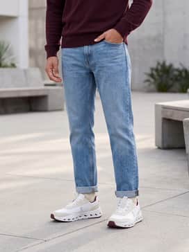 Straight-leg light-wash denim paired with a maroon crewneck sweater to highlight the shoe's subtle accent colors.