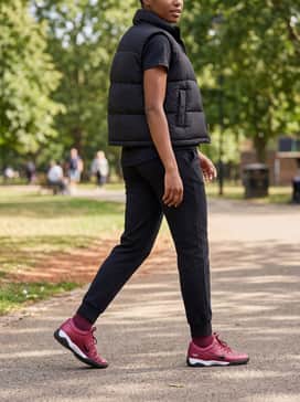 High-waisted black yoga leggings and a matching burgundy cropped hoodie with a black puffer vest for a coordinated, layered gym-to-street outfit.