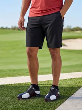 Lightweight moisture-wicking black shorts, a red performance tech shirt, and low-profile black athletic socks for a focused summer tournament look.