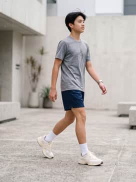 Navy blue mesh athletic shorts paired with a heather grey performance-fabric graphic tee and white crew socks.