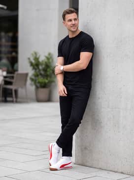Turino Ii Mens Sneakers – Black slim-fit joggers styled with a vintage-print graphic tee and a red snapback cap for a coordinated streetwear ensemble.