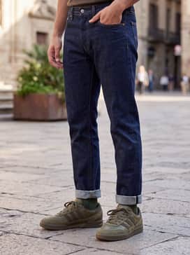 Classic dark-wash straight-leg jeans with a crisp white oversized button-down shirt and a vintage denim jacket for a timeless street style.