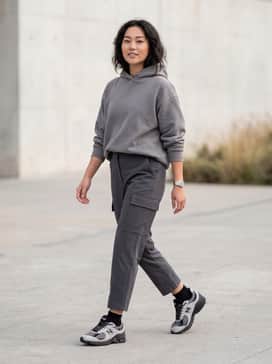Black oversized cargo pants paired with a heavyweight charcoal hoodie and a silver-toned metal watch for a monochromatic tech-wear inspired look.