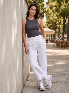 White wide-leg trousers combined with a tucked-in charcoal grey tank top and a silver-toned watch to lean into the 'clean girl' aesthetic.