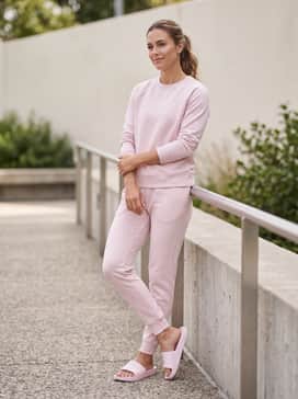 Ua Armr Shower – A monochromatic pale pink sweatset consisting of tapered joggers and a crewneck sweatshirt for the ultimate comfortable lounge outfit.