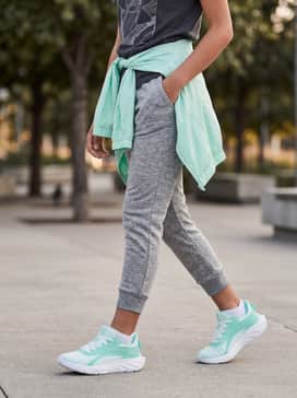 A comfortable school day ensemble consisting of grey marl joggers, a charcoal graphic t-shirt, and a lightweight mint windbreaker jacket for a coordinated finish.