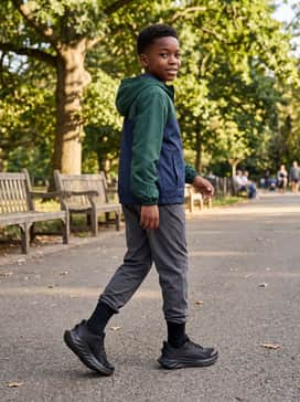 Ua Ascend Al – Khaki cargo pants and a lightweight zip-up windbreaker in a bold color-blocked design for weekend hiking or family outings.