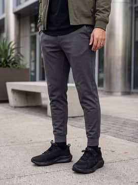Ua Assert 11 Camo – A clean streetwear ensemble with slim-fit black denim, a crisp white longline tee, and a structured olive green bomber jacket.