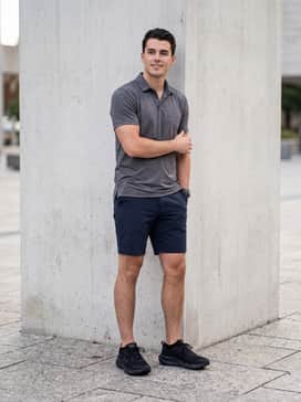 Ua Assert 11 Camo – A relaxed weekend outfit pairing navy blue tech-chino shorts with a heathered grey polo shirt and no-show socks for a streamlined profile.
