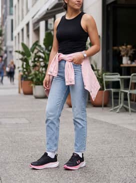 Ua Assert 11 Wide D – Straight-leg light-wash denim jeans with a simple tucked-in black bodysuit, topped with a pink oversized denim jacket to tie in the shoe's accent colors.