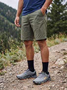 Ua Bandit Trail 3 – A rugged hiking ensemble consisting of olive green ripstop cargo shorts, a navy blue technical tee, and grey crew-length performance socks.
