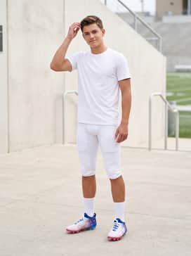 Ua Blur Pro Usa – Integrated-pad football pants in a sleek matte white, worn with mid-calf white athletic socks to allow the colorful blue-to-white transition of the cleats to pop.