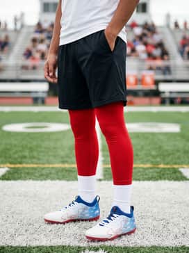 Ua Blur Select Jr Usa – Red compression leggings worn under black mesh athletic shorts and a white moisture-wicking performance T-shirt for training drills.
