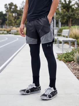 Ua Brigade Xc 2 – Full-length technical compression leggings paired with a breathable long-sleeve base layer for cold-weather training sessions on the grass.
