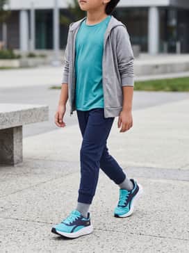 Ua Charged Ascend – Navy blue athletic joggers paired with a matching teal moisture-wicking t-shirt and a lightweight grey zip-up hoodie.