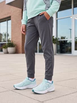 Ua Charged Chase Al – Tapered charcoal joggers with a matching mint-accented hoodie for a stylish and comfortable athleisure outfit suitable for travel or weekends.