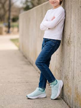 Classic dark-wash denim jeans and a simple white long-sleeved shirt for a neat yet practical ensemble for casual social gatherings.