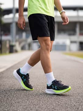 A neon green moisture-wicking tech tee paired with black athletic shorts and white crew socks for a high-performance track look.