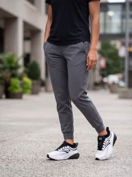 Ua Charged Rogue 6 – A casual athleisure look featuring tapered grey jersey joggers, a black graphic hoodie with a minimalist logo, and a matching black baseball cap for low-key weekend errands.
