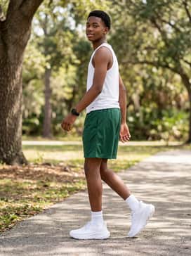 Ua Charged Turbulence 3 – Style for warm weather with mesh basketball shorts in a forest green and a white performance tank top to keep the look light and airy.