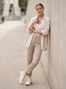 Ua Charged Verssert 2 – Style with cropped beige trousers, a tucked-in white silk camisole, and an unbuttoned oversized linen shirt for a sophisticated yet comfortable day look.
