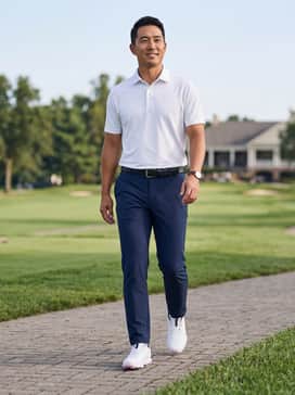 Ua Drive Pro Clone Le – Tailored navy blue performance trousers, a crisp white moisture-wicking polo, and a black leather belt to coordinate with the branding.
