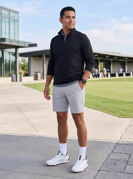 Ua Drive Pro Clone Le – Light grey tech shorts, a black quarter-zip pullover, and white athletic socks for a sleek, contemporary golf look.