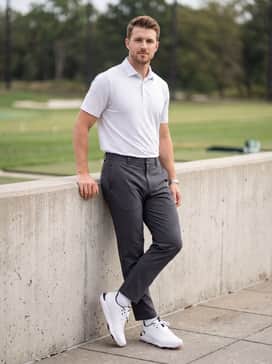Ua Drive Pro Clone Le – Tapered charcoal golf pants paired with a polo featuring subtle pink patterns to highlight the unique outsole color.