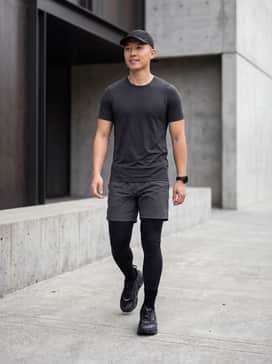 Ua Explor Trail – A high-performance look featuring black compression leggings under charcoal ripstop shorts, paired with a fitted moisture-wicking charcoal tee and a lightweight running cap.