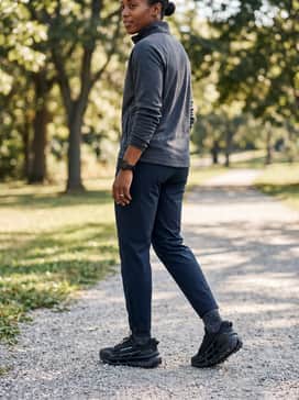 Ua Explor Trail – A streamlined athletic set with dark navy tapered track pants, a quarter-zip athletic fleece, and performance socks that sit just above the ankle collar.
