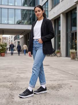 Straight-leg light-wash denim jeans with a slight roll at the cuff, a tucked-in white organic cotton tee, and an oversized black blazer for a smart-casual contrast.