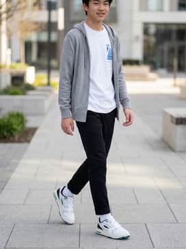 Slim-fit black joggers paired with a crisp white graphic t-shirt featuring blue lettering and a grey lightweight zip-up hoodie.