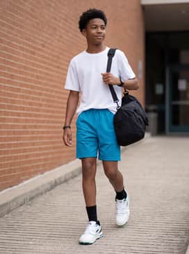 Bright blue mesh athletic shorts combined with a white moisture-wicking tank top and black crew-length socks for an energized sports practice outfit.