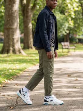 Durable olive green cargo pants styled with a simple black long-sleeve shirt and an unbuttoned denim jacket for a layered, urban-inspired ensemble.