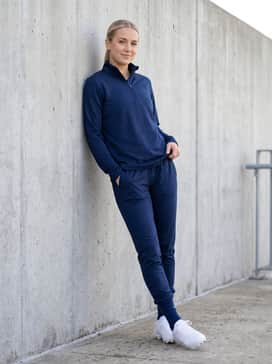Ua Glyde Sola Pro Tpu – A coordinated team warm-up suit consisting of a navy blue quarter-zip training pullover and matching tapered joggers for pre-game drills and sideline comfort.