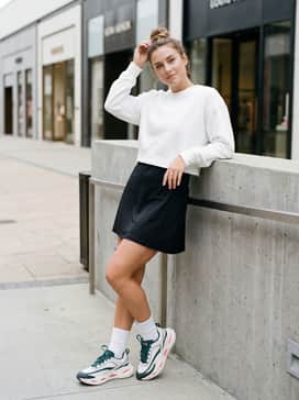 Ua Halo Racer – A sleek black tennis dress with a cropped white hoodie and high-performance crew socks to emphasize the chunky aesthetic of the sole.