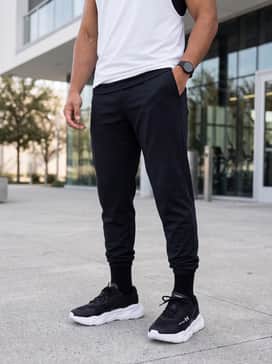 A classic gym ensemble consisting of tapered black athletic joggers with elastic cuffs to highlight the chunky white midsole, and a breathable white muscle tank.