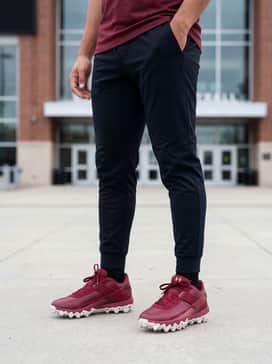 Pre-game warm-up outfit featuring tapered black athletic joggers, a moisture-wicking compression shirt, and a lightweight team windbreaker.