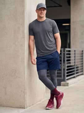 Ua Harper 10 Pro Tpu – Practice session look with mesh navy blue shorts, a moisture-wicking grey graphic tee, and a structured baseball cap.