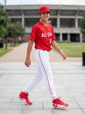 Ua Harper 10 Rm Jr – A full team uniform featuring white baseball pants with thin red piping, a matching red jersey, and a solid red baseball cap.