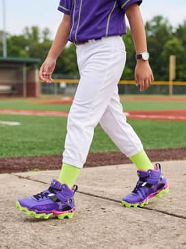 Ua Harper 10 Rm Jr Pe Mad House – A professional-style youth baseball uniform consisting of crisp white baseball pants, a matching purple jersey, and neon green stirrup socks to highlight the cleat's vibrant outsole.