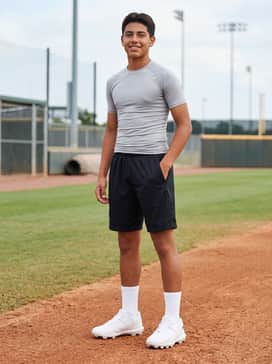Ua Harper 10 Tpu Jr – A high-performance practice look consisting of black mesh athletic shorts, a light gray compression shirt, and padded white crew socks for maximum comfort on the diamond.