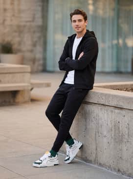 Match with tapered black tech-fleece joggers and a matching zip-up hoodie to create a streamlined, athletic silhouette that emphasizes the white and green contrast.
