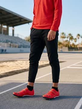 Ua Hovr Skyline Long Jump – Warm-up ensemble featuring black tapered tech fleece joggers and a matching red quarter-zip athletic pullover to emphasize the footwear.
