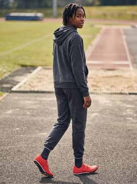 Ua Hovr Skyline Long Jump – Post-competition recovery outfit including a branded oversized hoodie, relaxed-fit athletic pants, and high-performance crew socks.