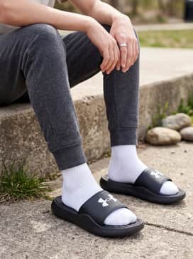 Ua Ignite Pro 8 Fixed Strap – A cozy loungewear outfit pairing charcoal fleece joggers with an oversized navy blue hoodie, perfect for traveling to sports tournaments or relaxing at home.