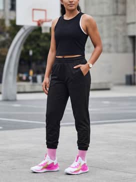 Ua Jet 23 – High-waisted black compression leggings and a gold-accented sports bra under a cropped white mesh tank top for a high-intensity training session.