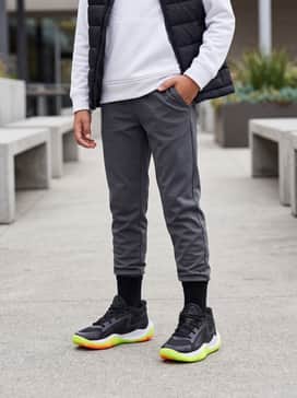 A cool school-day attire with charcoal grey tapered joggers, a crisp white hoodie, and a black puffer vest for layering during transitional weather.