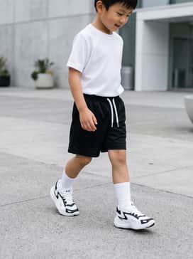 Ua Jet 25 Preschool – A full athletic kit featuring black mesh basketball shorts, a moisture-wicking white graphic tee, and mid-calf crew socks for a court-ready look.