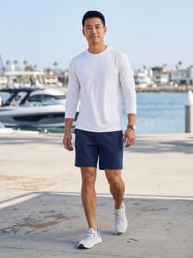 Ua Kilchis Camo – A maritime-inspired look featuring navy blue moisture-wicking performance shorts, a crisp white UV-protective long-sleeve shirt, and a technical sun hat for a day on the water.